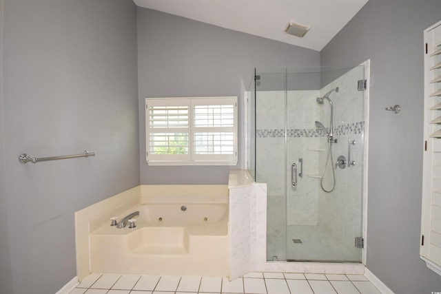 bathroom featuring tile patterned flooring, vaulted ceiling, a shower stall, and a tub with jets