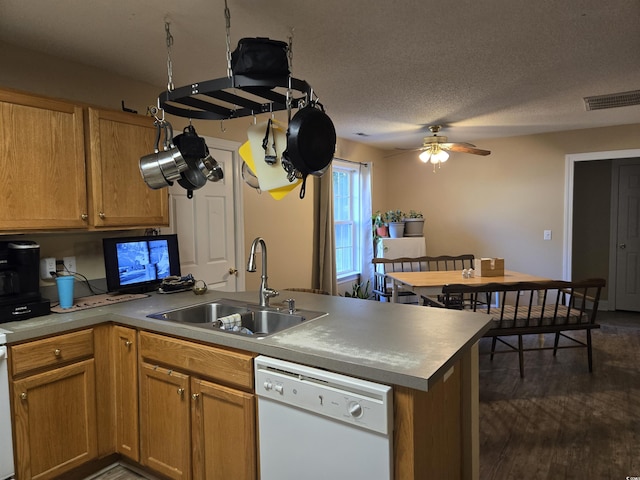 kitchen with sink, dark wood-type flooring, white dishwasher, a textured ceiling, and kitchen peninsula