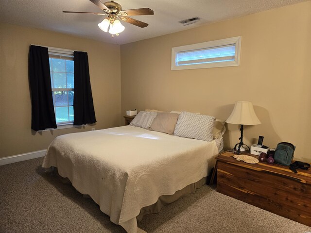 bedroom featuring multiple windows, ceiling fan, and carpet