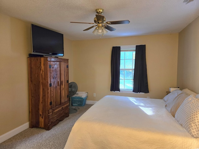 carpeted bedroom with ceiling fan and a textured ceiling