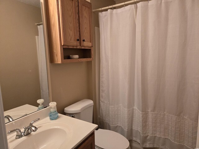 bathroom with a shower with curtain, vanity, and toilet