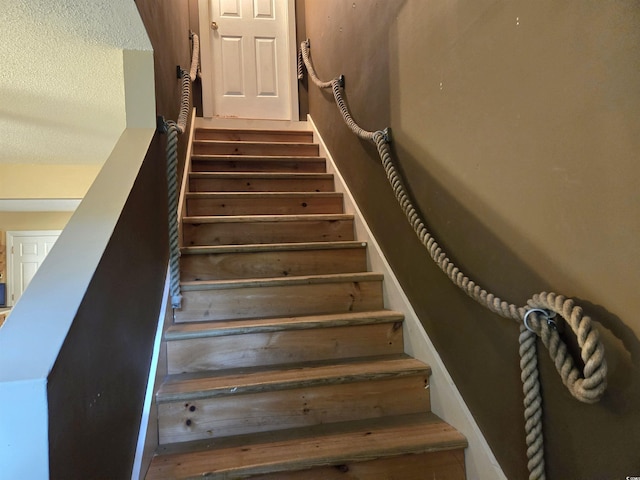 stairway with a textured ceiling