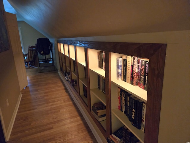 corridor featuring lofted ceiling and hardwood / wood-style floors
