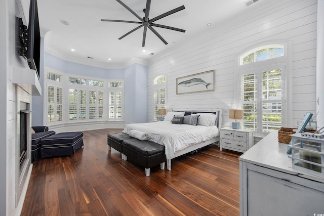 bedroom featuring dark wood-style floors, ornamental molding, a fireplace, and recessed lighting