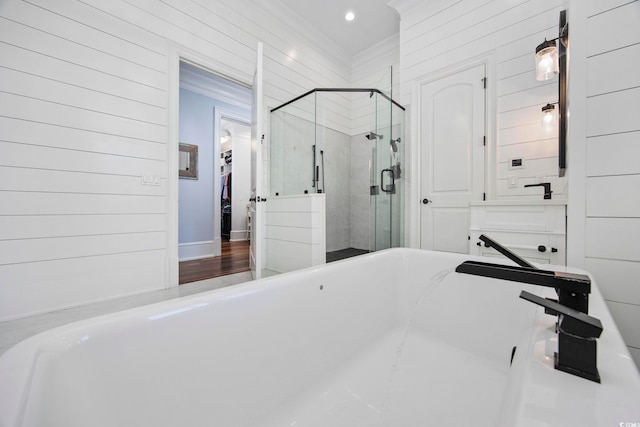 bathroom featuring crown molding, wood-type flooring, and shower with separate bathtub