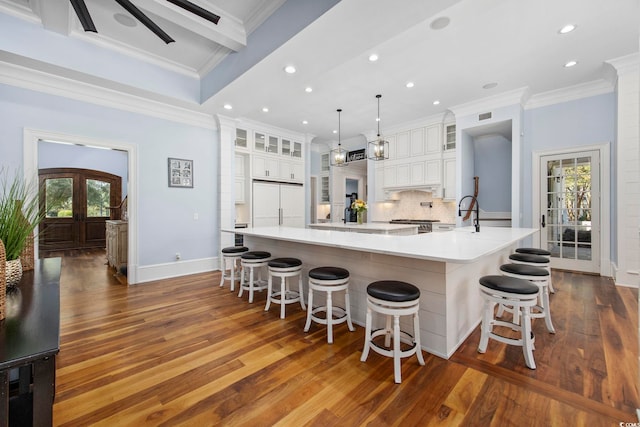 kitchen featuring dark wood-type flooring, a breakfast bar, a healthy amount of sunlight, and hanging light fixtures