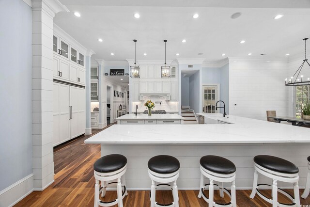 kitchen featuring a kitchen bar, hanging light fixtures, and dark hardwood / wood-style floors