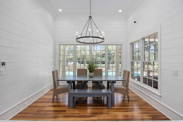 dining space with plenty of natural light, dark wood finished floors, and a notable chandelier