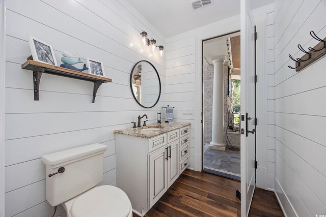 9318 Cove Dr, Myrtle Beach, SC 29572 - bathroom featuring wood finished floors, vanity, toilet, and decorative columns