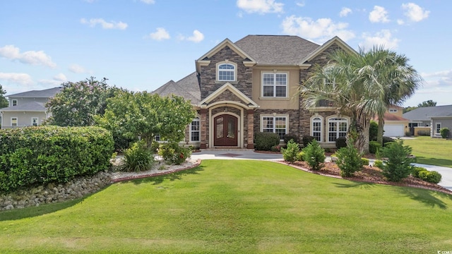 view of front of home with a front yard and a garage