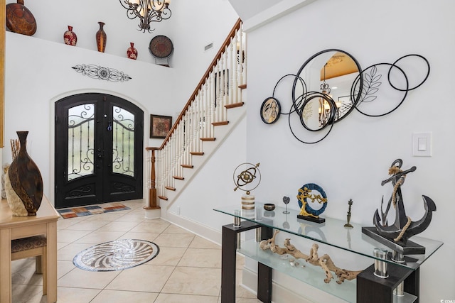 entrance foyer featuring french doors, a chandelier, and light tile patterned flooring