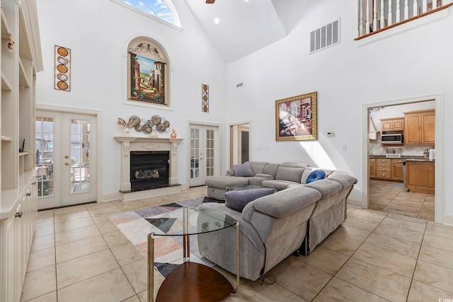 tiled living room with ceiling fan, high vaulted ceiling, french doors, and a fireplace