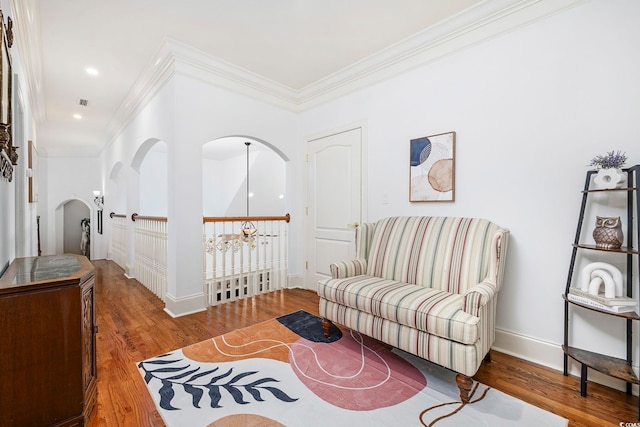 living area with hardwood / wood-style flooring and ornamental molding