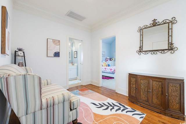 sitting room with light hardwood / wood-style floors and ornamental molding