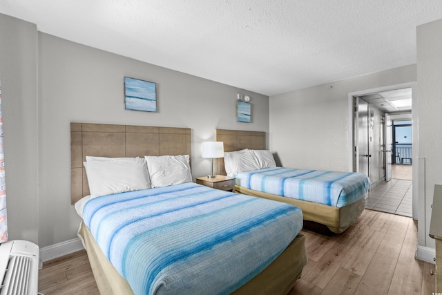 bedroom with light hardwood / wood-style flooring and a textured ceiling