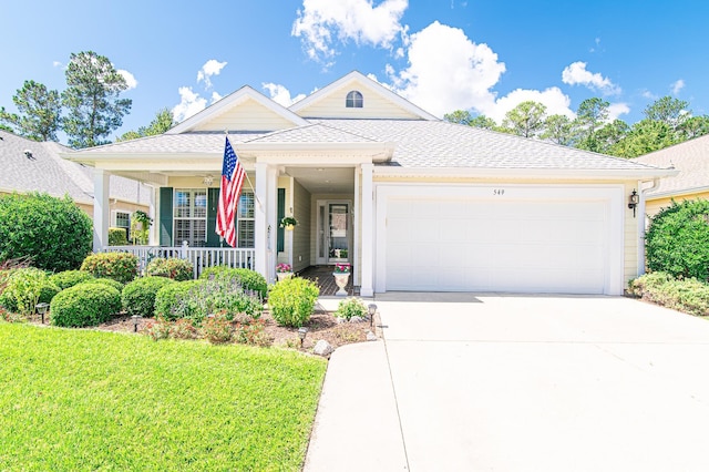 view of front of home with a porch, a garage, and a front lawn