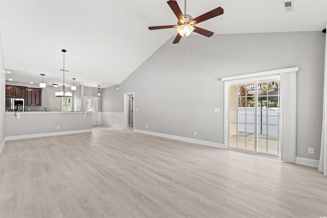 unfurnished living room featuring light wood-style flooring, visible vents, baseboards, and ceiling fan with notable chandelier