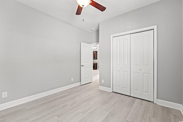 unfurnished bedroom featuring light wood-style floors, ceiling fan, baseboards, and a closet