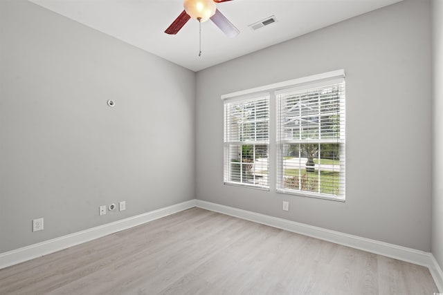 spare room featuring visible vents, light wood-style flooring, and baseboards