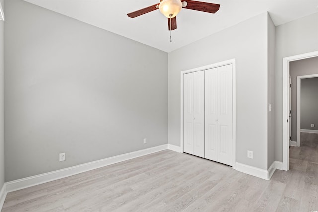 unfurnished bedroom featuring light wood-style floors, a closet, ceiling fan, and baseboards