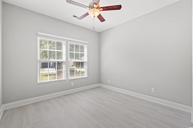 unfurnished room with ceiling fan, light wood-style floors, visible vents, and baseboards