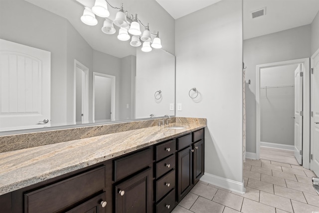 bathroom featuring baseboards, visible vents, tile patterned floors, a spacious closet, and vanity