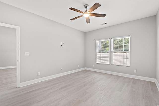 empty room with light wood-style floors, visible vents, baseboards, and a ceiling fan