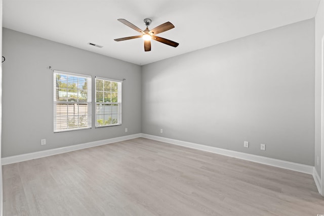 unfurnished room featuring visible vents, light wood-style floors, a ceiling fan, and baseboards