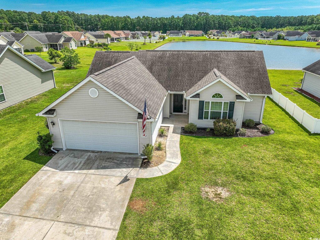 ranch-style house featuring a water view, a front yard, and a garage