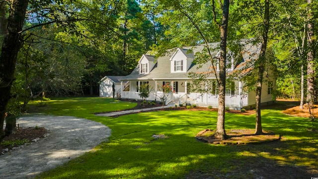 new england style home featuring a porch and a front lawn