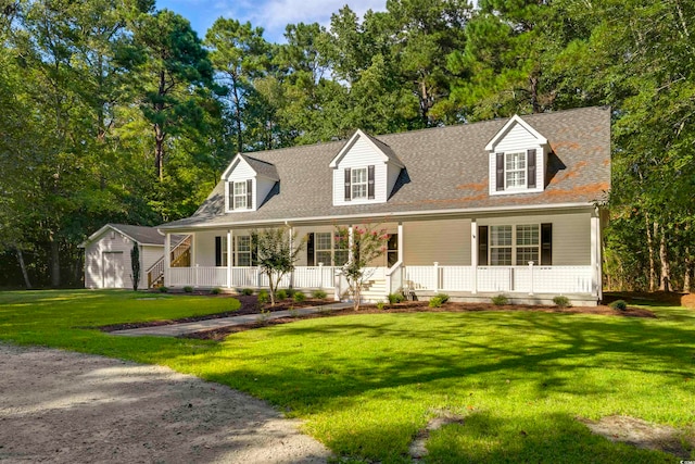 cape cod-style house with a storage unit, a front lawn, and a porch