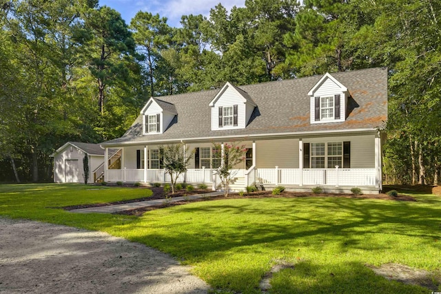 3758 Loblolly Ave, Little River, SC 29566 - cape cod home featuring a garage, a front yard, a shingled roof, a porch, and an outbuilding