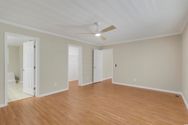 unfurnished bedroom with a walk in closet, ceiling fan, light wood-type flooring, a closet, and ensuite bath