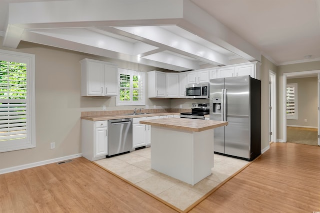 kitchen featuring a kitchen island, sink, white cabinets, appliances with stainless steel finishes, and light hardwood / wood-style floors