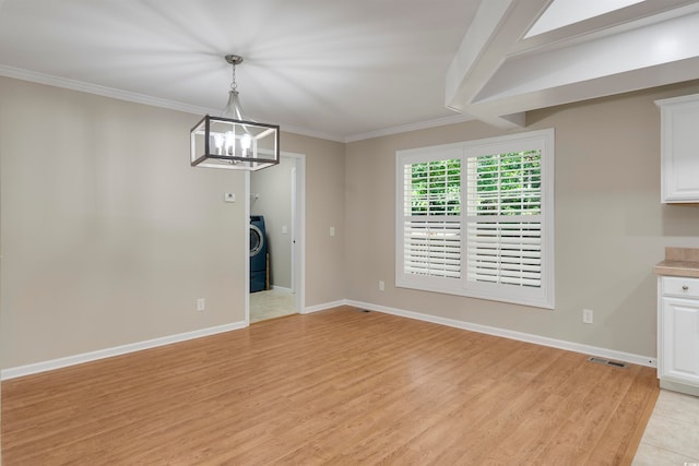 unfurnished dining area featuring crown molding, a notable chandelier, washer / clothes dryer, and light hardwood / wood-style flooring