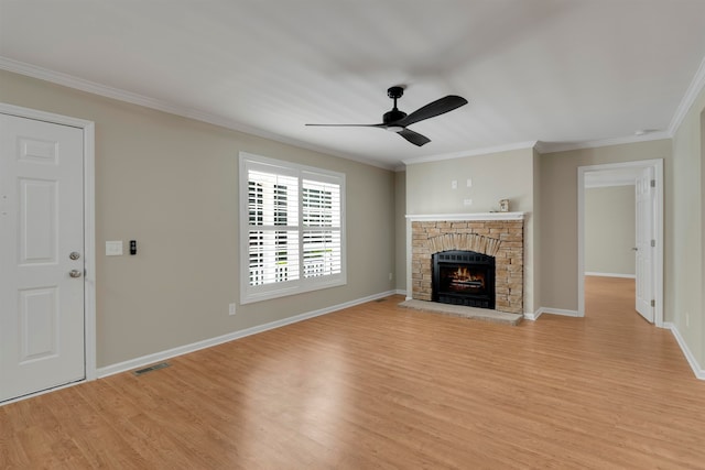 unfurnished living room with crown molding, a fireplace, light wood-type flooring, and ceiling fan