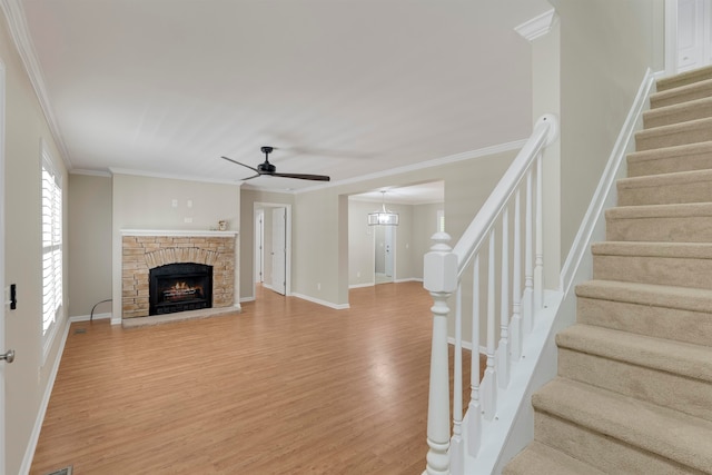 unfurnished living room featuring ornamental molding, hardwood / wood-style flooring, a fireplace, and ceiling fan