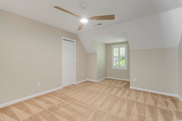 bonus room with ceiling fan, vaulted ceiling, and light colored carpet