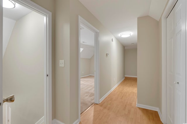 hall featuring vaulted ceiling and light hardwood / wood-style floors