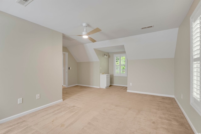 additional living space with light carpet, vaulted ceiling, and ceiling fan