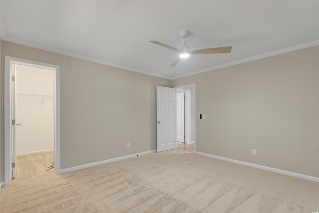 spare room with ornamental molding, light colored carpet, and ceiling fan