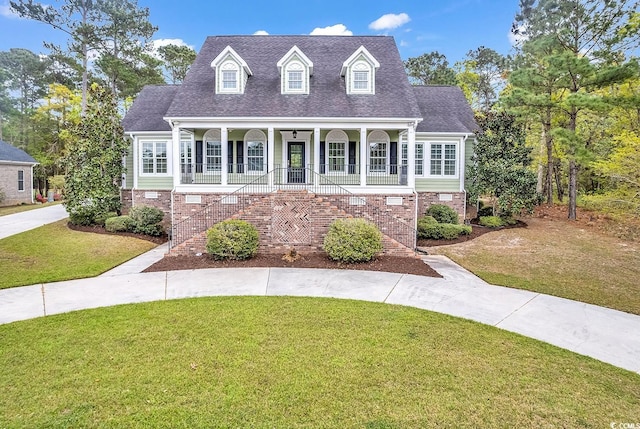 new england style home with covered porch and a front yard