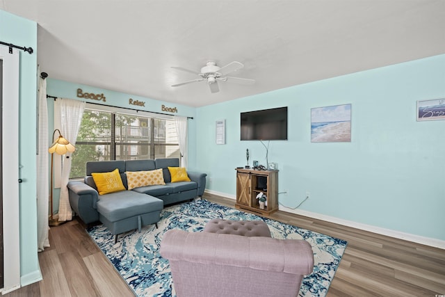 living room featuring ceiling fan and hardwood / wood-style floors