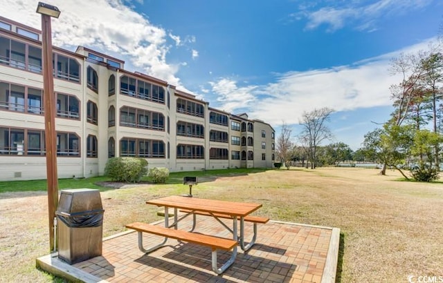 view of home's community with a yard and a patio area