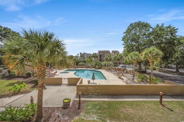 view of swimming pool featuring a patio and a lawn