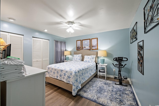 bedroom featuring two closets, ceiling fan, and hardwood / wood-style flooring