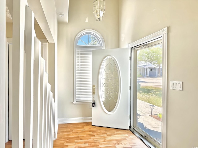 foyer with light wood-style floors, baseboards, and a wealth of natural light