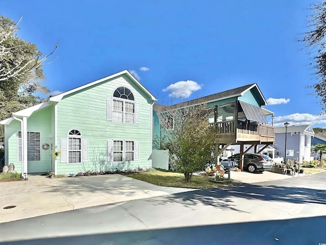 view of front of property with a deck, a carport, and concrete driveway