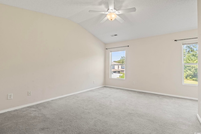 carpeted empty room with a textured ceiling, lofted ceiling, and ceiling fan