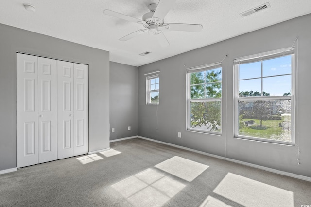 unfurnished bedroom featuring ceiling fan, a closet, and multiple windows